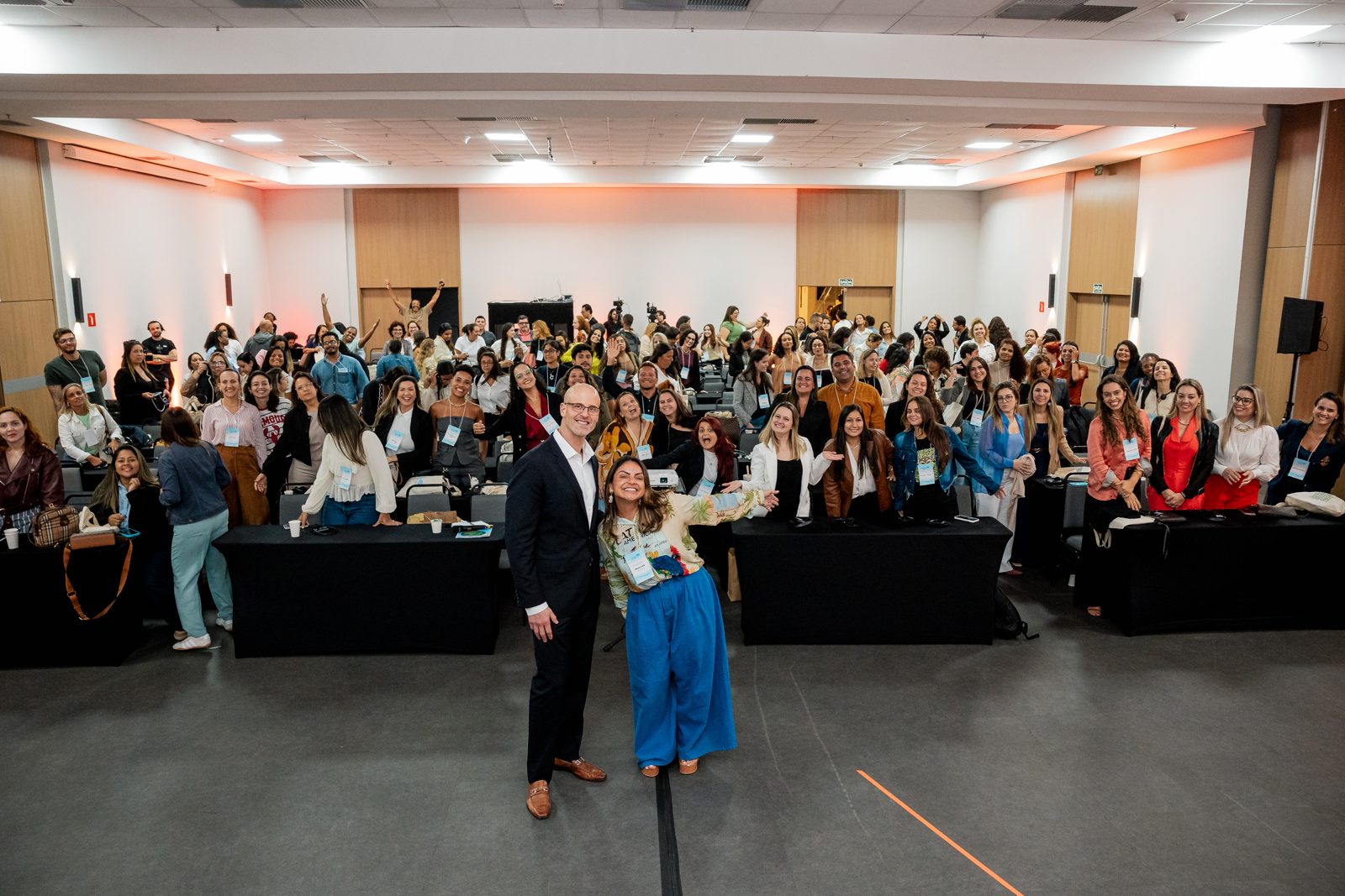 Paula Lins e Jake Greenspan à frente da turma da Formação, em um auditório cheio